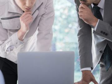 ノートパソコンをのぞき込む二人の男性